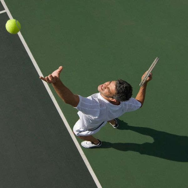 Man serving tennis ball