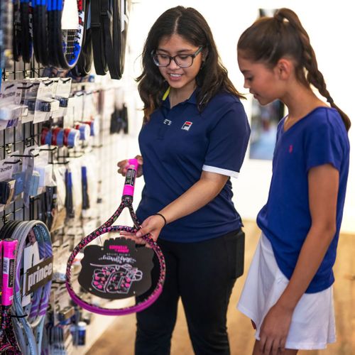 store associate helping with tennis gear store associate helping with tennis gear