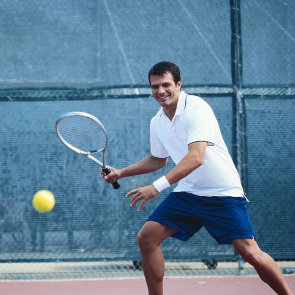 man in white shirt playing tennis