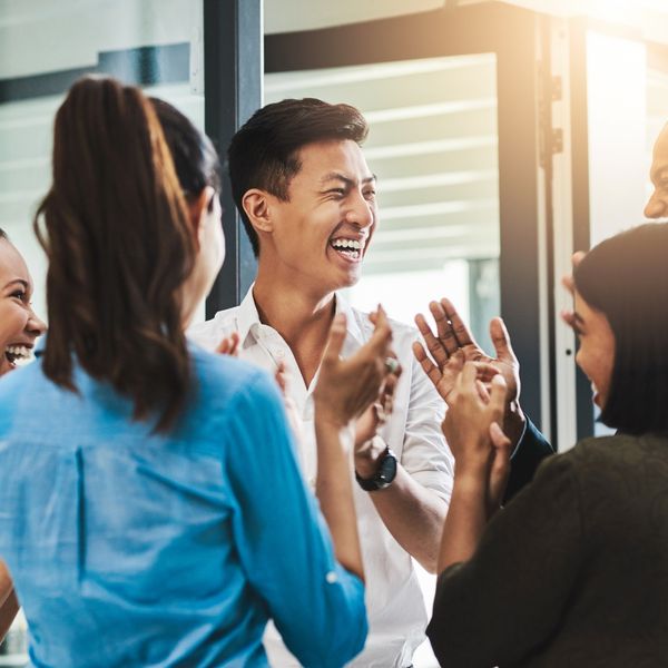 Office coworkers clapping and laughing