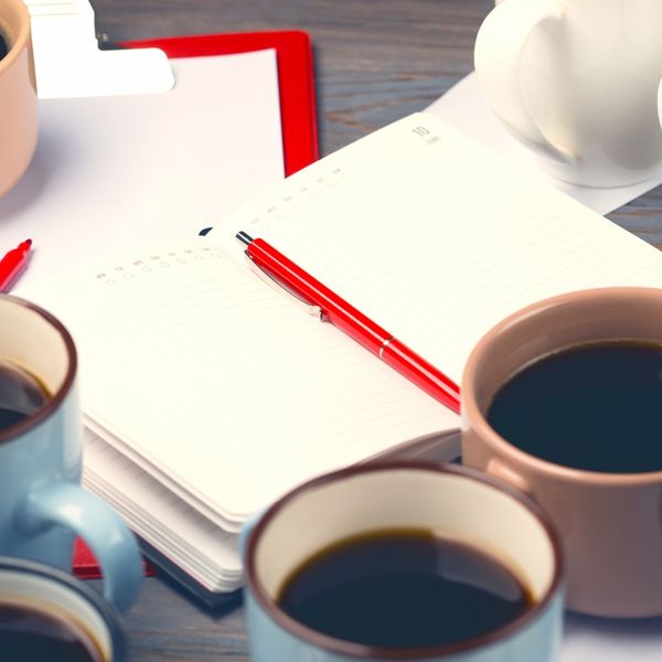 Coffee cups next to notebook