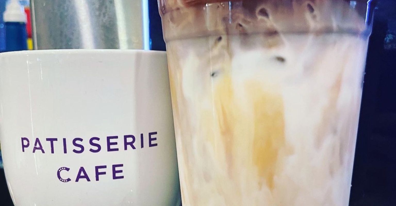 Patisserie Cafe mug next to a latte cup