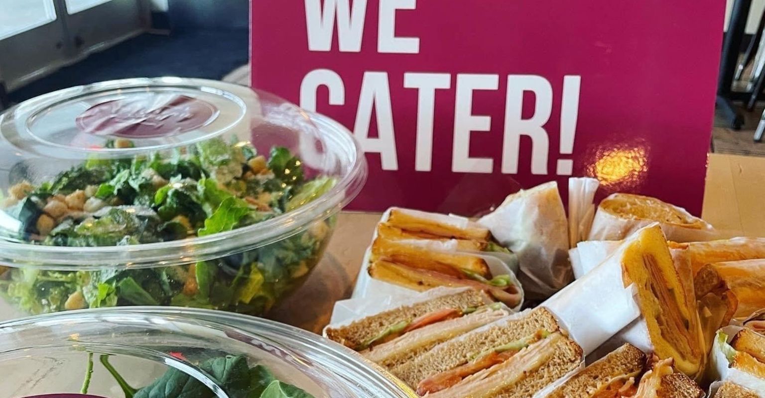 "We Cater!" sign and various catering bowls/trays