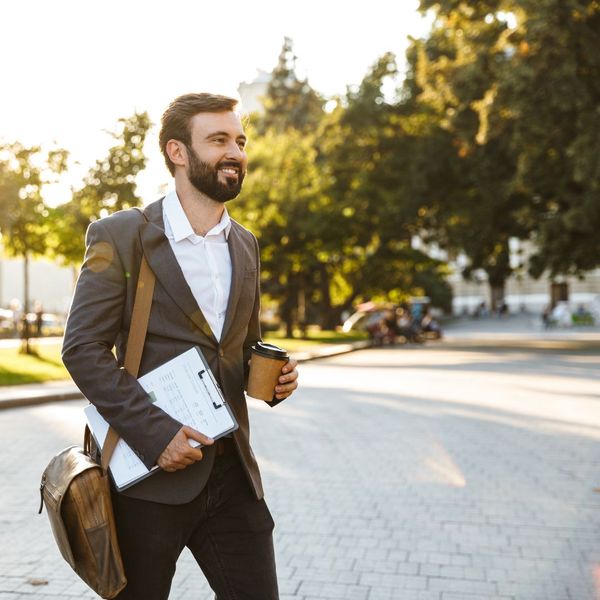 Happy Businessman Walking to Work with Coffee