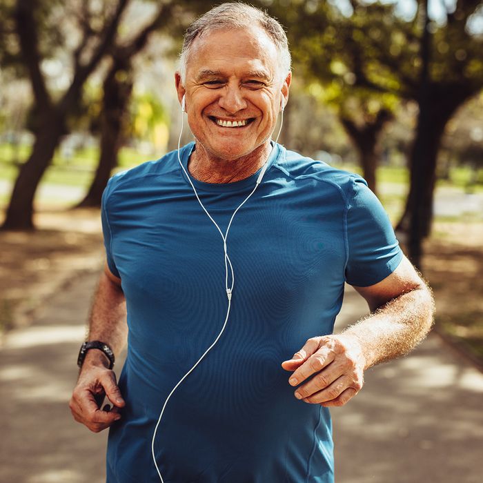 Happy man jogging and listening to headphones