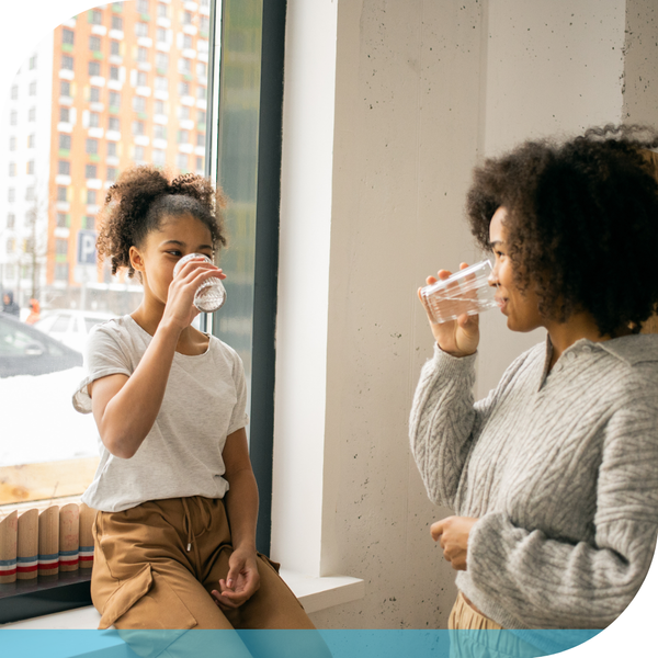 woman drinking water with child woman drinking water with child
