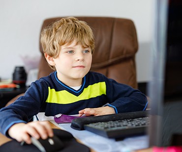 Young boy doing schoolwork on computer
