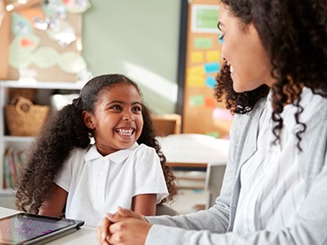 Little girl smiling at her teacher
