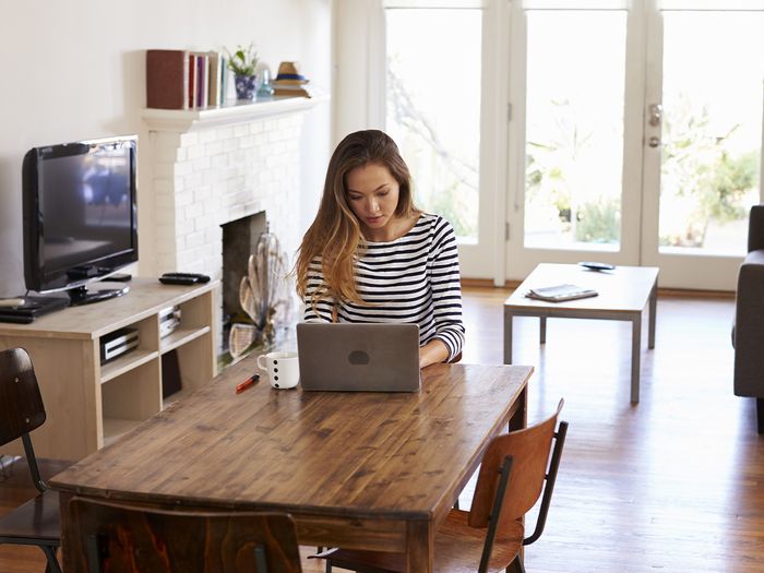 Image of a woman using a laptop while working from home.