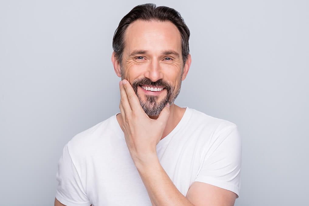 mature man smiling in white tshirt