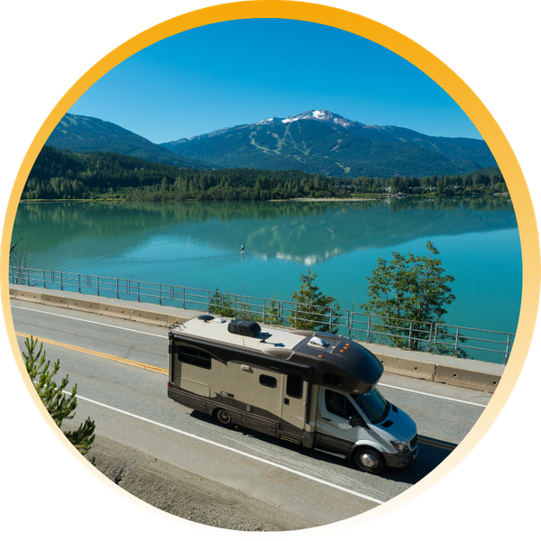 rv driving down road by lake