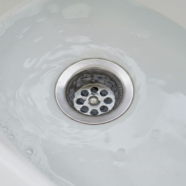 a clogged drain in a home, showing water struggling to go down a clogged drain in a home, showing water struggling to go down