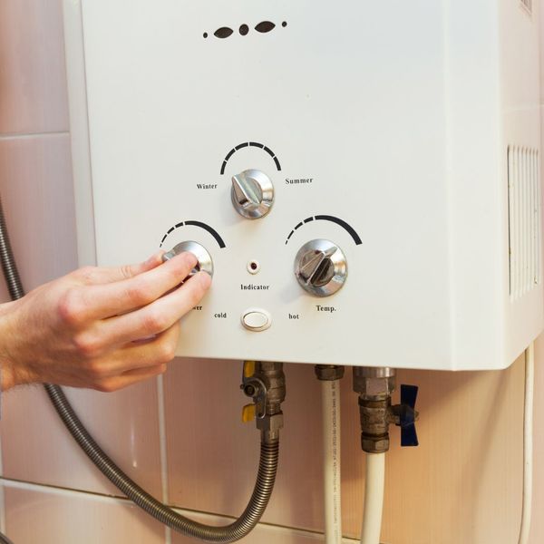person adjusting a hot water heater