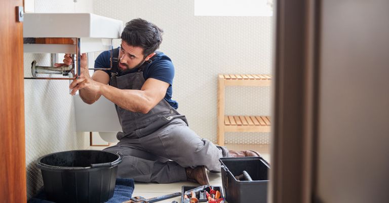 plumber working on sink