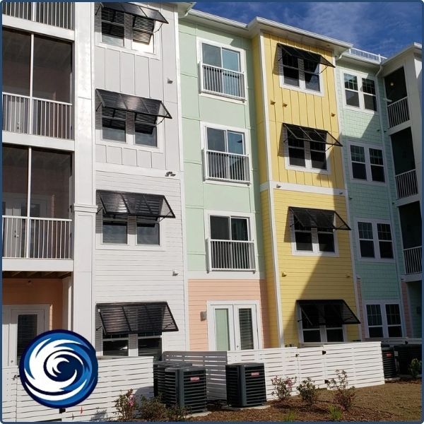 Modern colorful townhomes featuring black Bahama shutters on multiple levels, providing a uniform look and solar heat reduction.