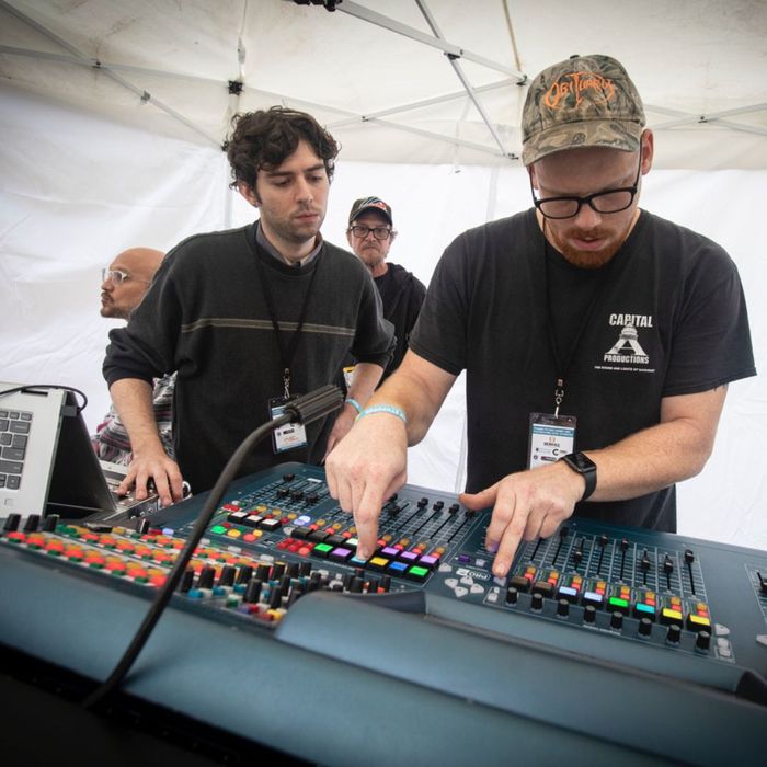 workers using the sound board at a venue