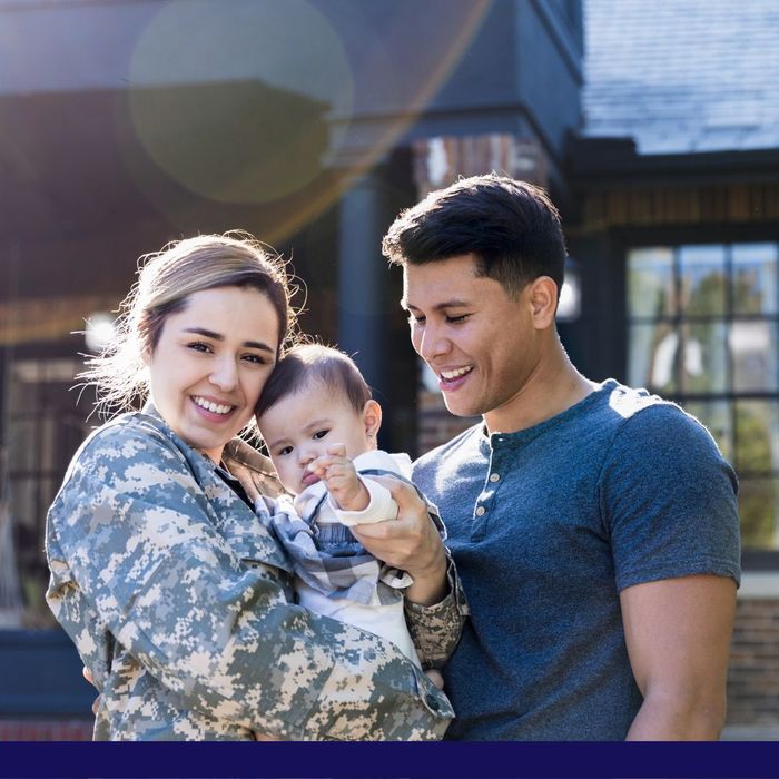 Military woman with husband and baby outside their home