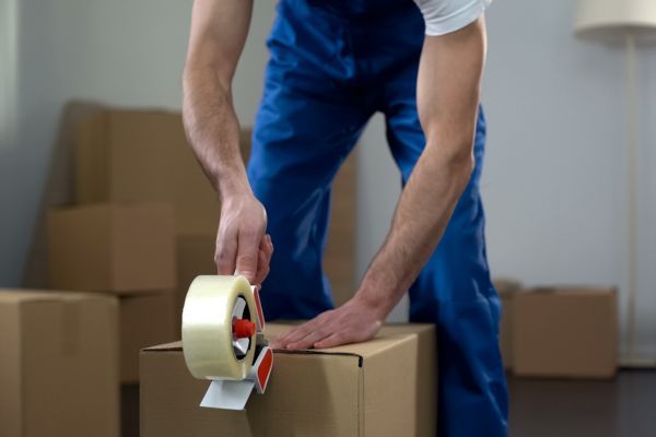 man taping up a moving box