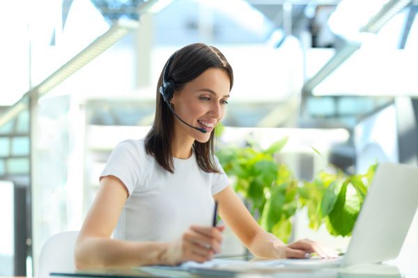 woman on laptop with headset on 