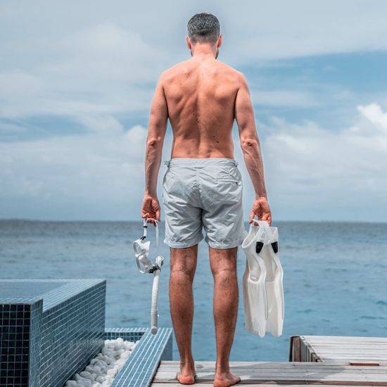 ear view of a fit, athletic man standing by the ocean with snorkeling gear—representing peak physical performance and vitality after TRT or weight management. ear view of a fit, athletic man standing by the ocean with snorkeling gear—representing peak physical performance and vitality after TRT or weight management.