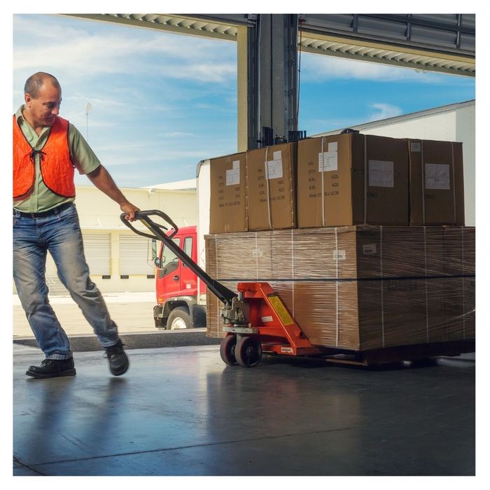 Worker dragging pallets