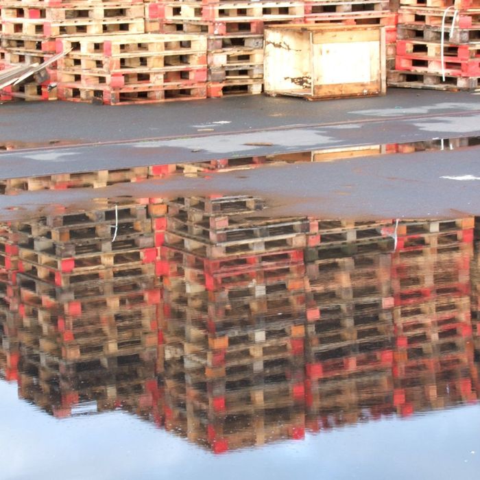 Wooden pallets being reflected off a puddle of water