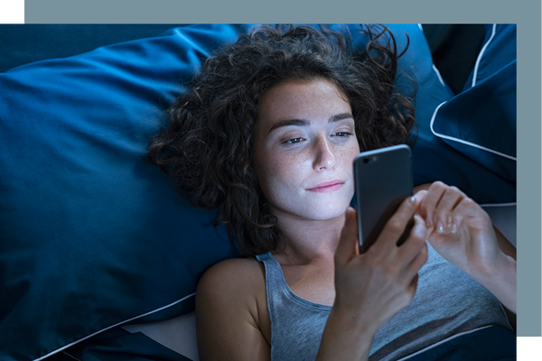 woman using phone in bed