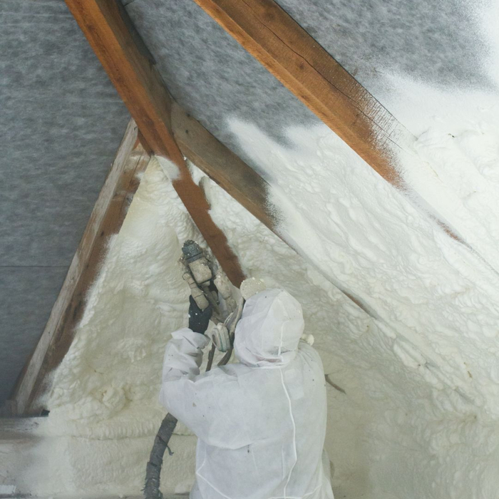 man using spray insulation gun