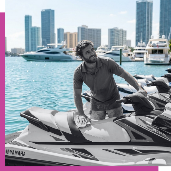 a team member prepping a jet ski at the dock with a friendly, genuine smile