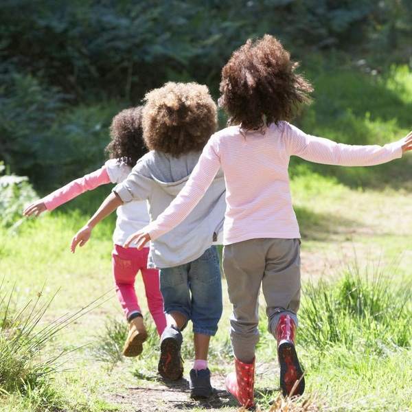 Three kids walking down a grassy path Three kids walking down a grassy path