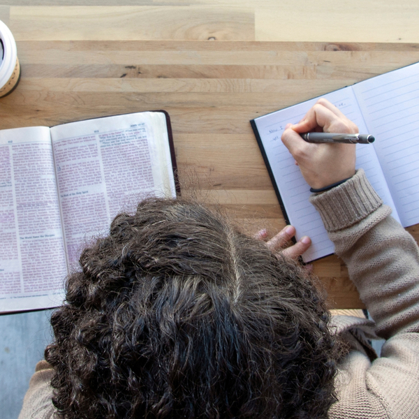 woman taking notes on bible