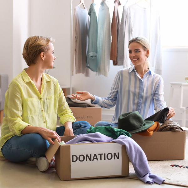 Two women conversing and filling boxes for donation. 
