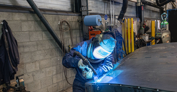 Person welding on large sheet of metal