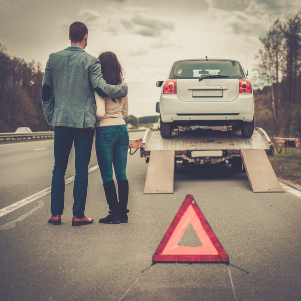 two people hugging on the side of the road. 