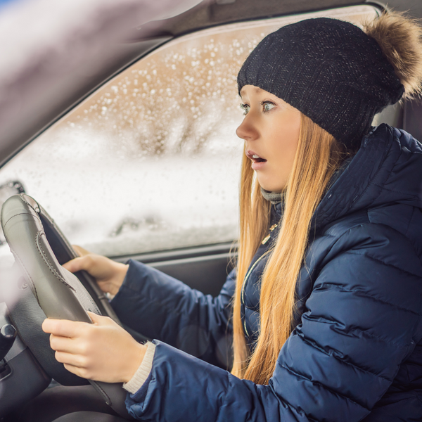 woman looking alarmed in a car. 