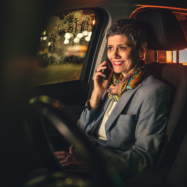 woman sitting in a car on a phone. 