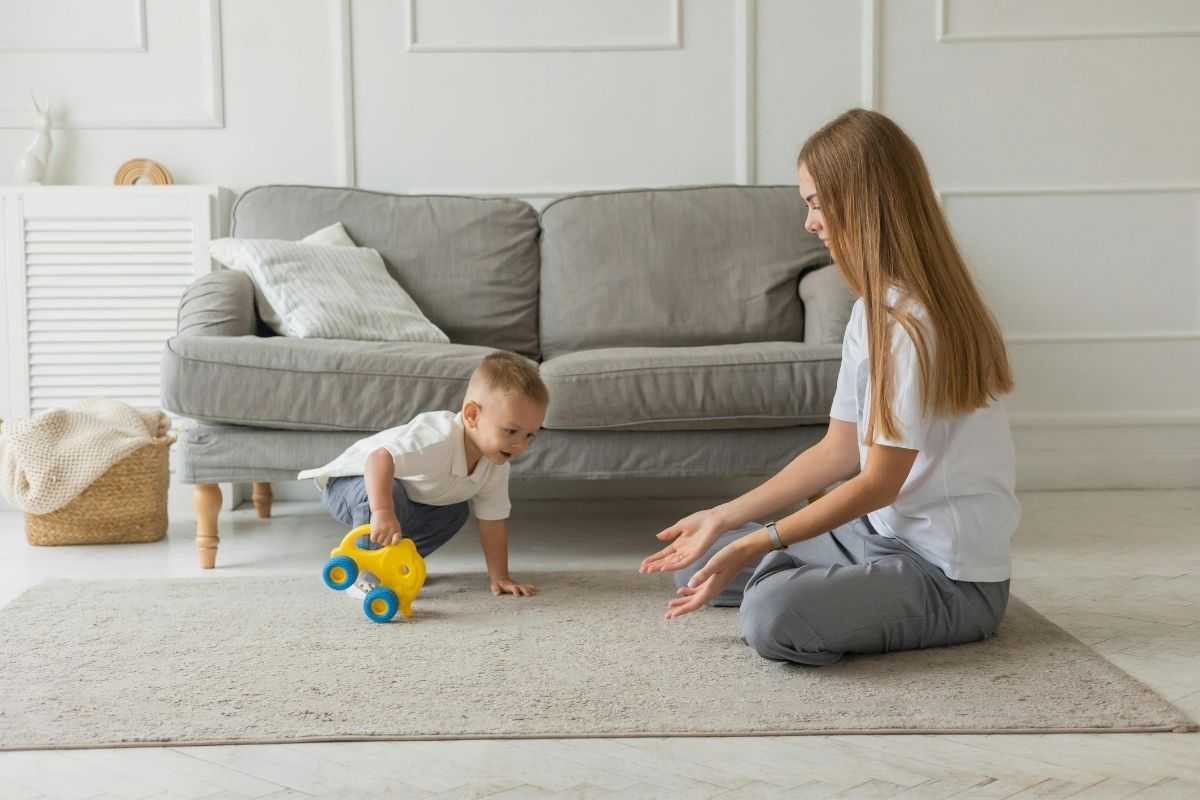 baby and mom playing on carpet