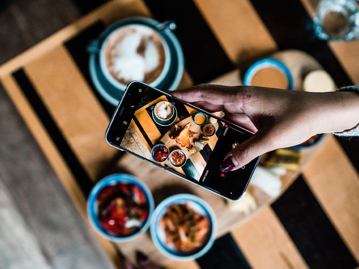 a person taking a photo of their charcuterie boards