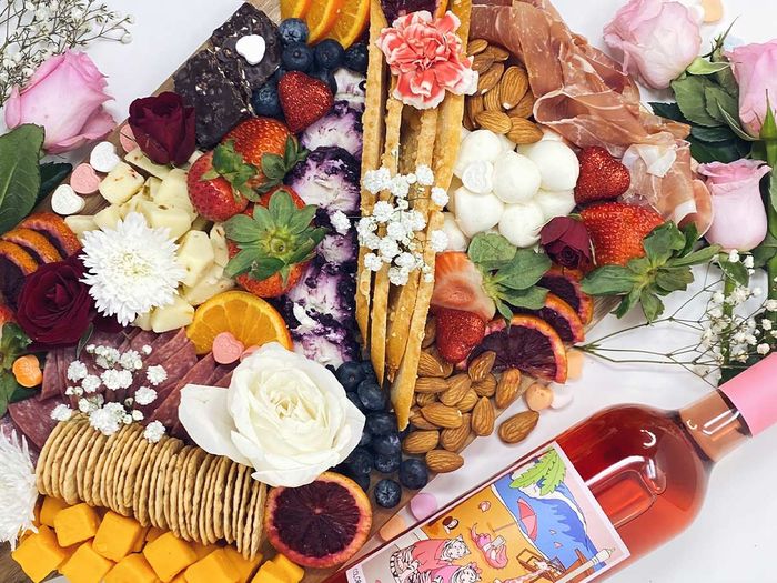 flowers and food decorated on a charcuterie board