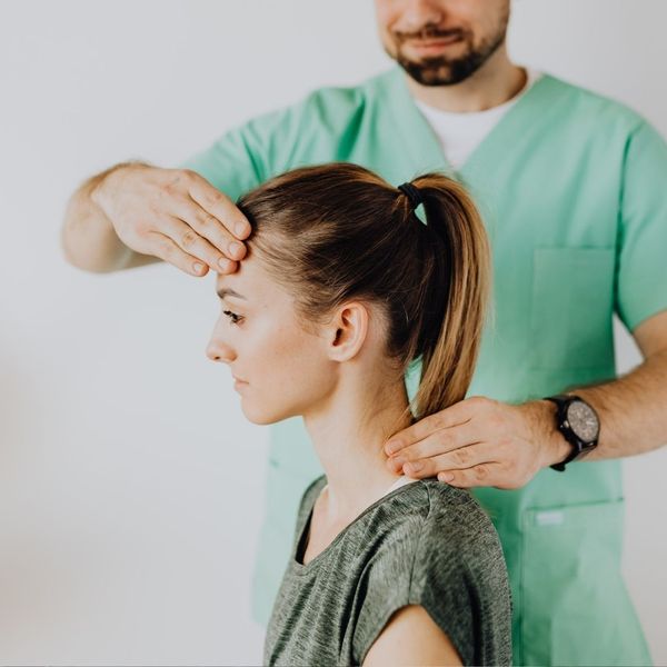 chiropractor carefully adjusting neck for headaches