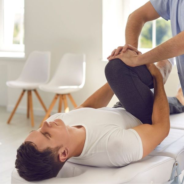chiropractor holding client's leg for adjustment