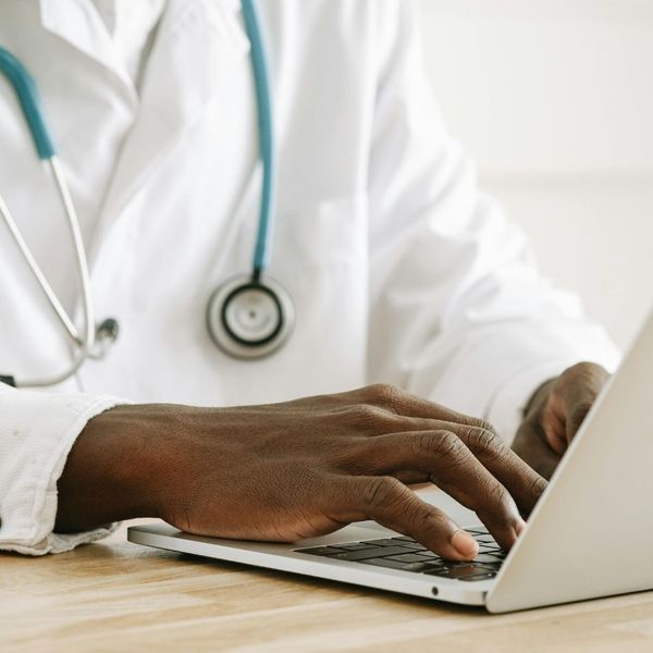 doctor typing notes into a laptop