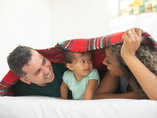 family under blanket in their home