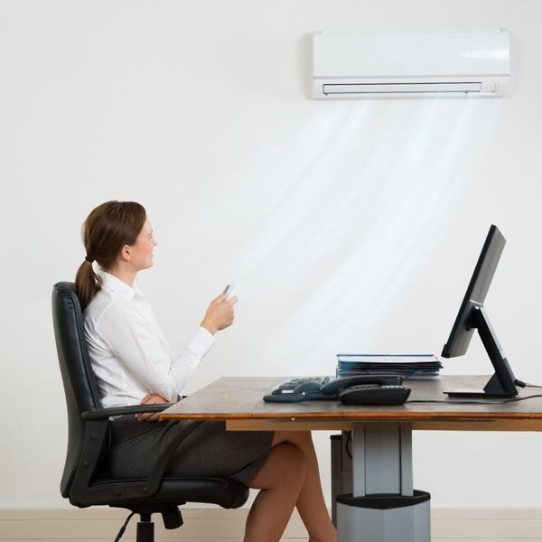 Woman turning cool air on with ductles ac unit