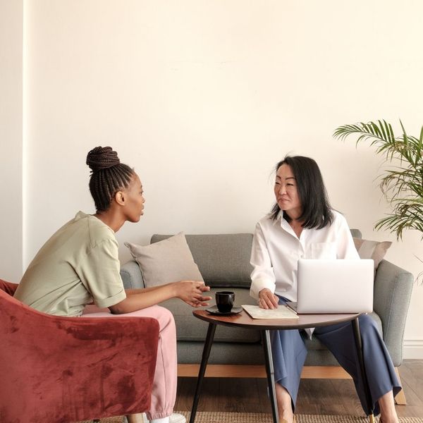 therapist taking notes on patient with laptop