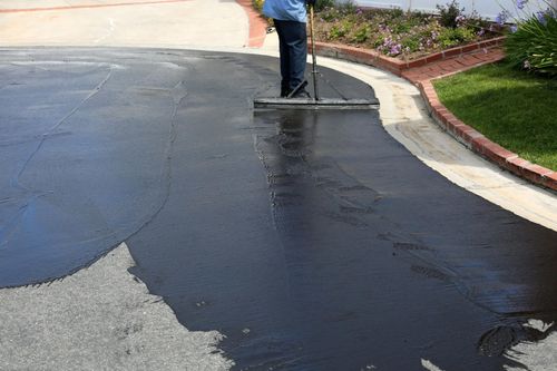 Image of someone sealing asphalt