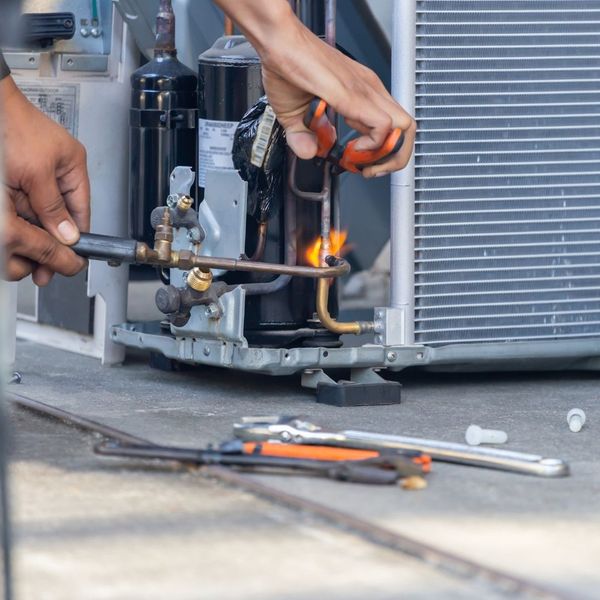 HVAC tech repairing AC