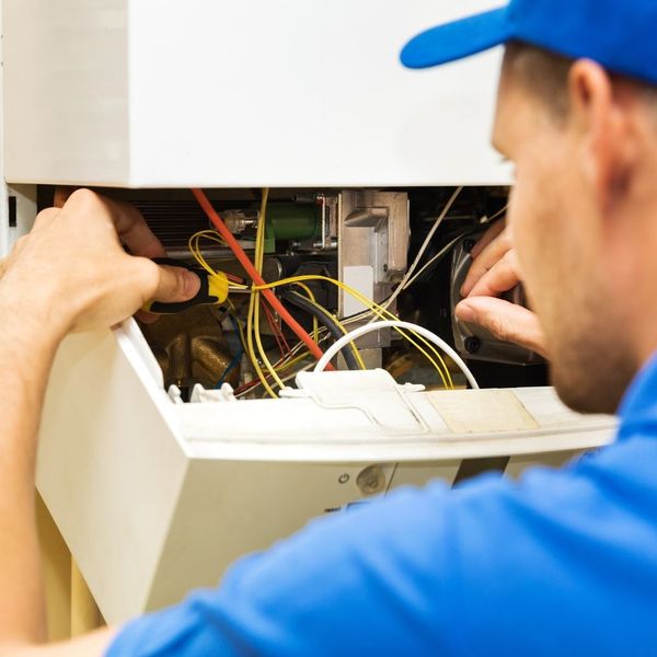HVAC tech repairing heater