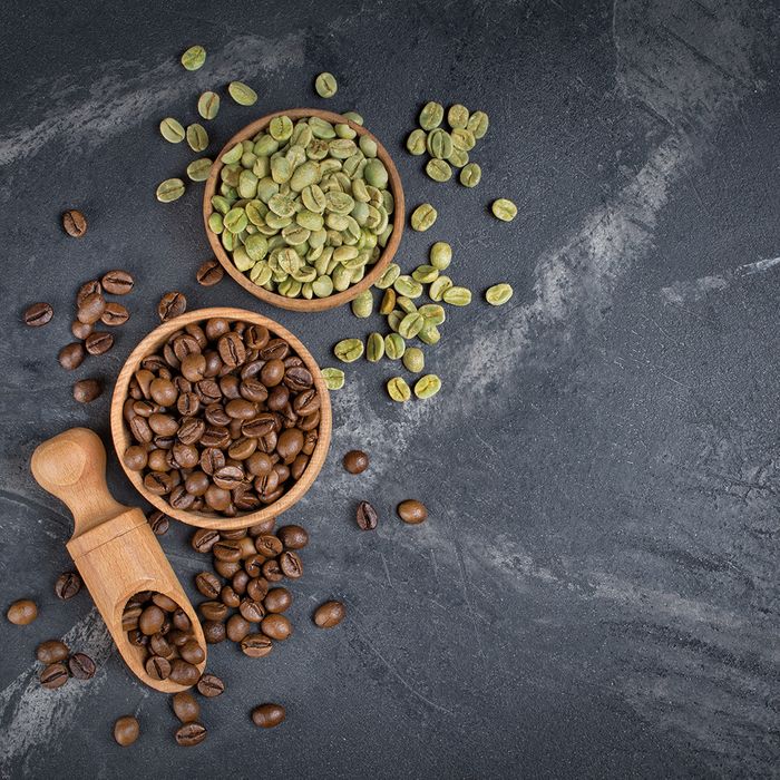 An image of roasted and green coffee beans in two bowls.