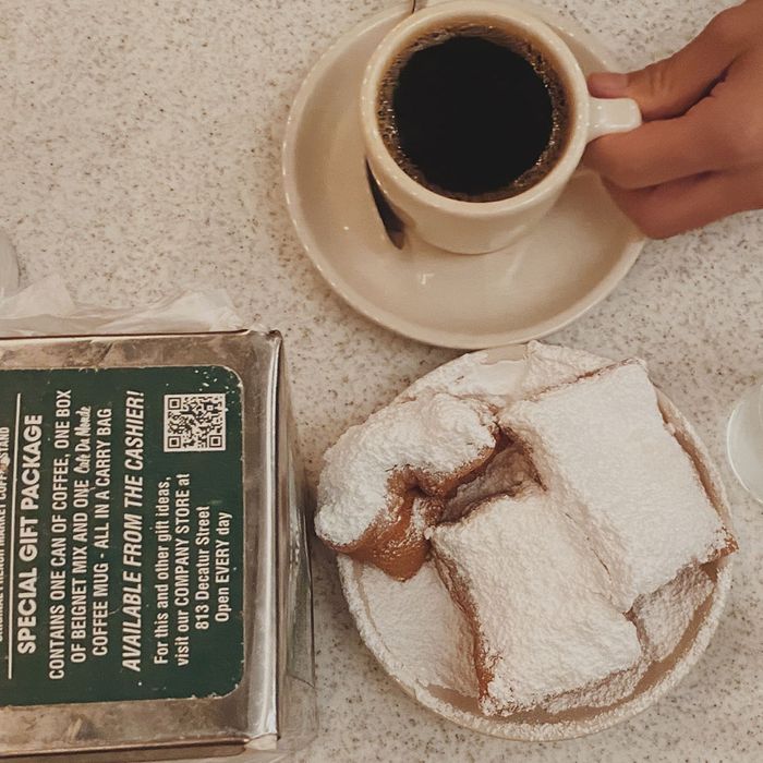 Beignets in a plate with coffee in a mug next to it